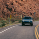 An image of a navy blue 2022 Rivian R1S driving on a road is shown.
